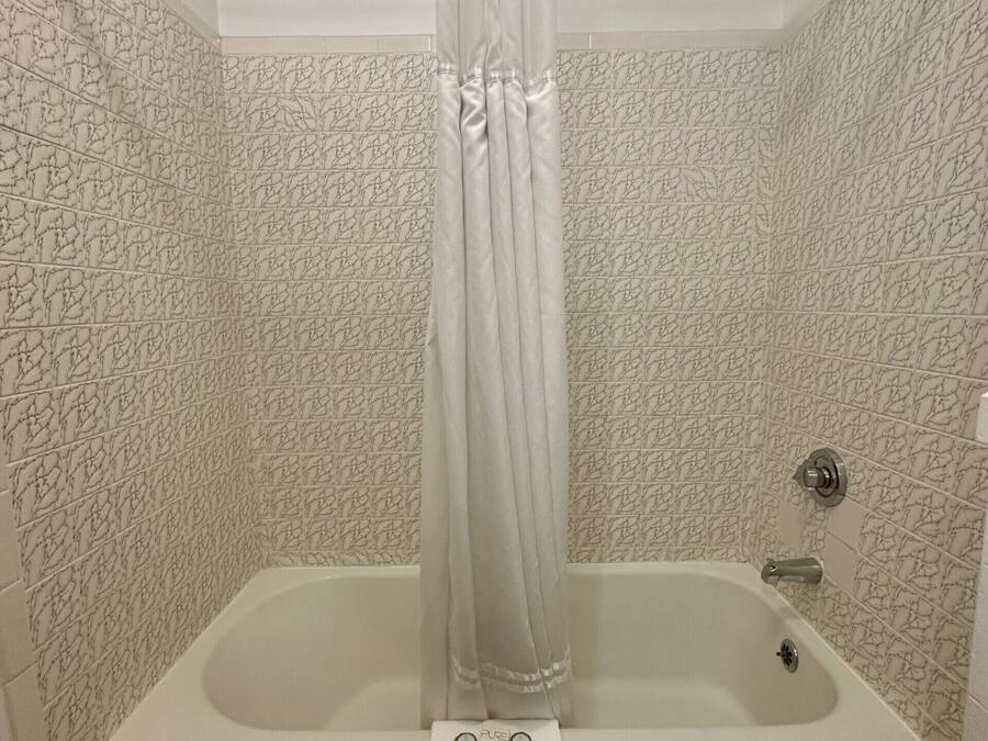 A bathroom with a bathtub, a shower, and a curtain.
