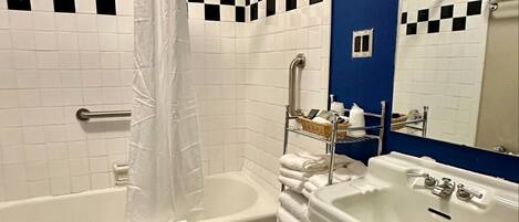 A bathroom with a bathtub, toilet, and sink.