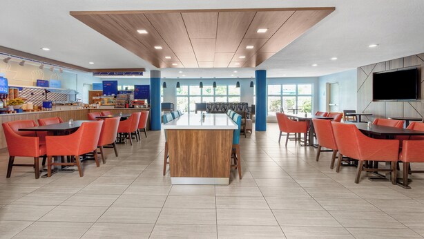 Un amplio comedor con una isla central, varias mesas y sillas.