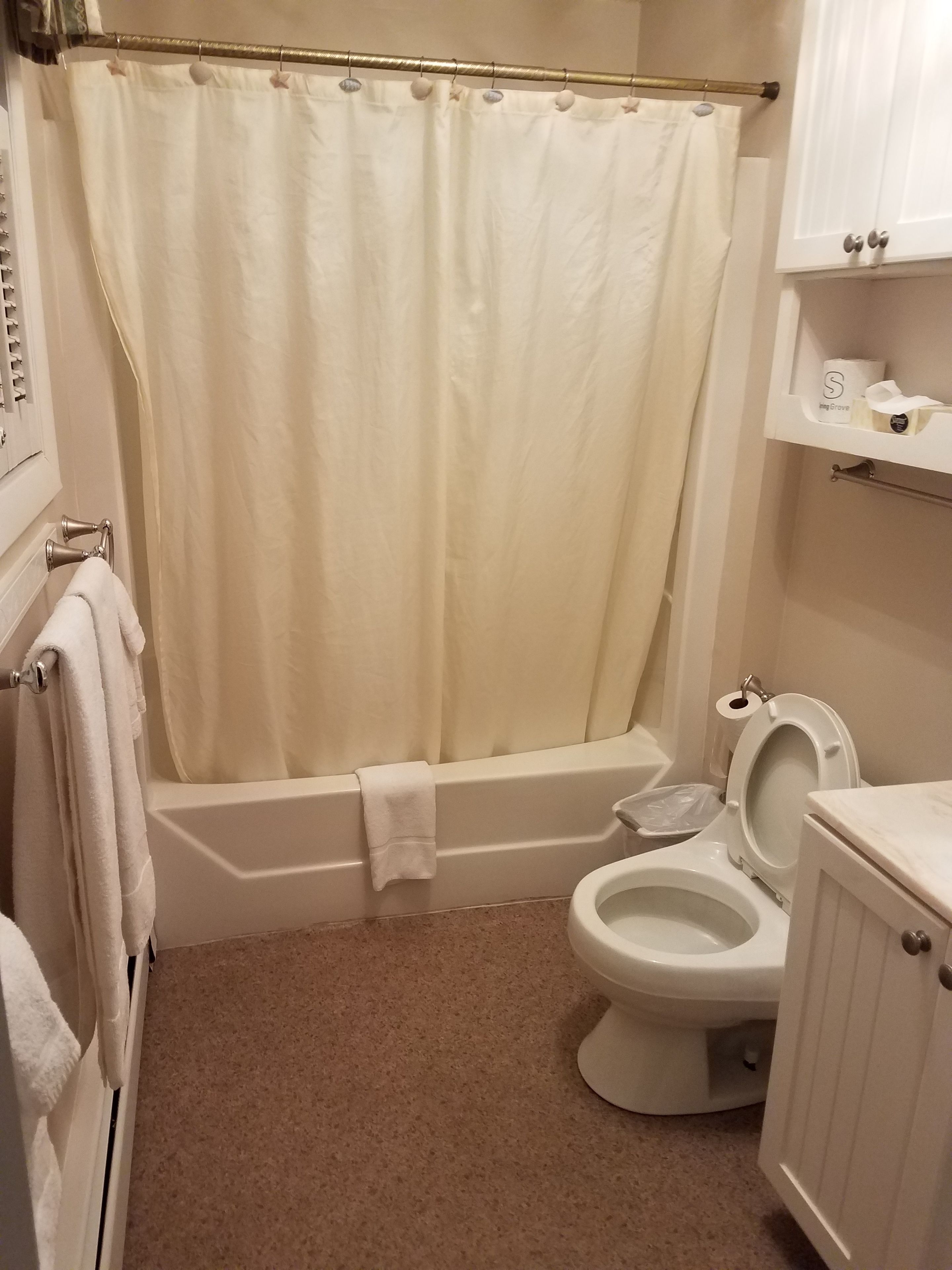 Un baño con bañera, inodoro y toallero.