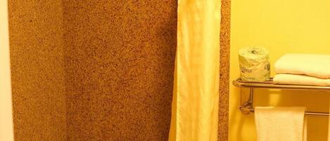 Ein Badezimmer mit Dusche, Toilette und Handtuchhalter.