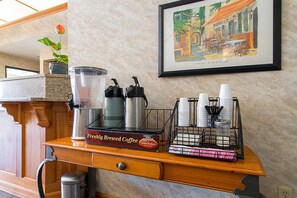 A coffee station with a coffee press, milk frother, and a coffee grinder on a wooden counter. - Econo Lodge Buckley Bonney Lake (Buckley)