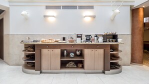 Une cuisine moderne dotée d’un îlot central, de rangements intégrés et d’un éclairage fixé au mur.