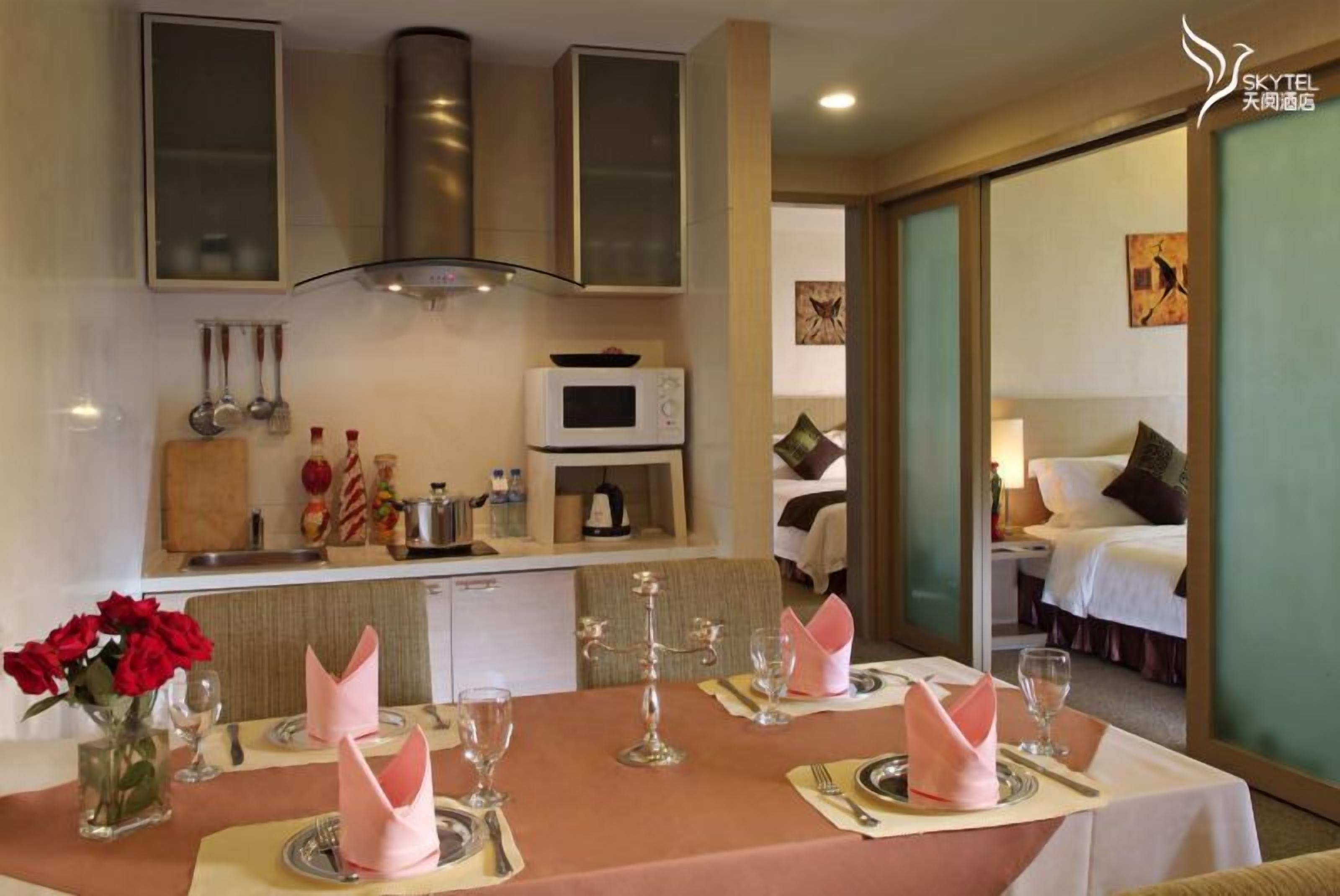 Une chambre d’hôtel avec un coin repas aménagé pour deux personnes, un four à micro-ondes et un lit avec vue.