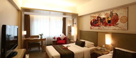 A hotel room with two beds, a desk, a television, and a painting on the wall.