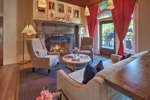 A cozy lobby with a fireplace, comfortable seating, and artwork on the walls.