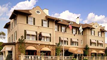 Classic two-story building with a stone facade and multiple windows with awnings.