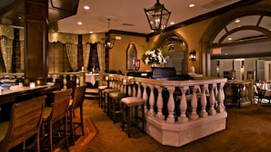 A bar area with a stone counter, wooden chairs, and a hanging light fixture. - Bernards Inn (Bernardsville)