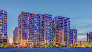 A high-rise hotel with multiple floors, balconies, and a waterfront view.