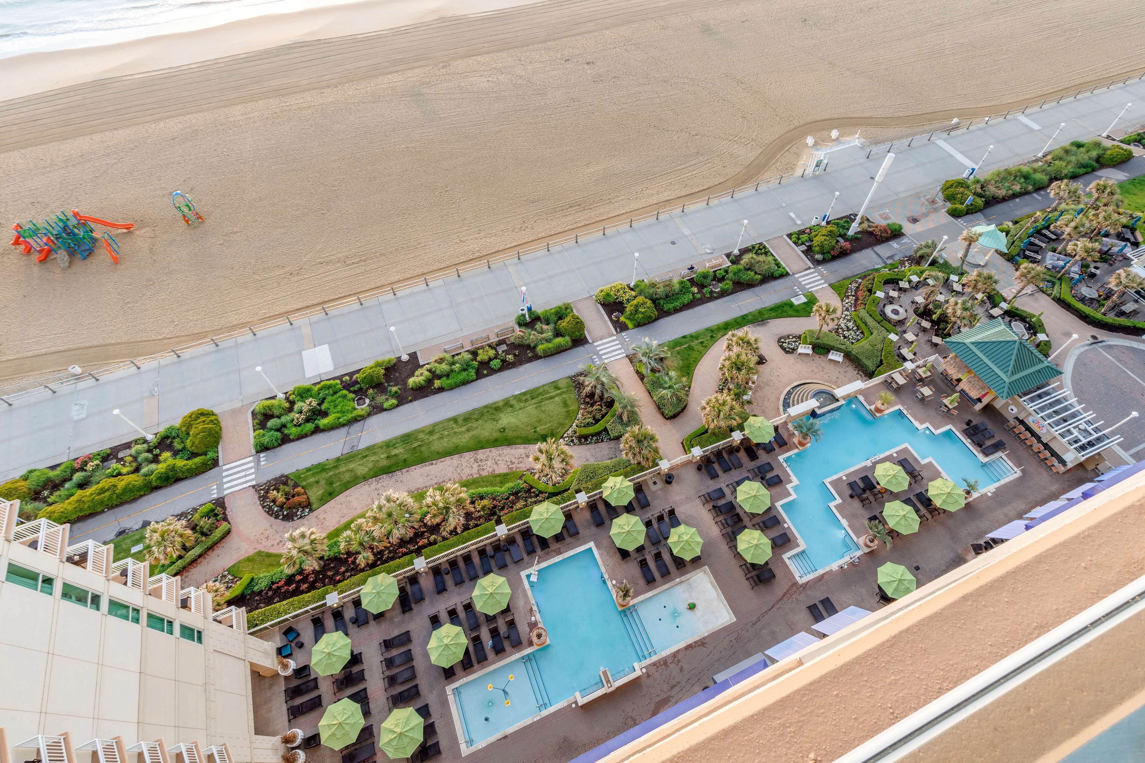 A resort with a swimming pool, lounge areas, and a beach.