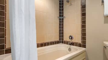 A bathroom with a bathtub, shower, and toilet.