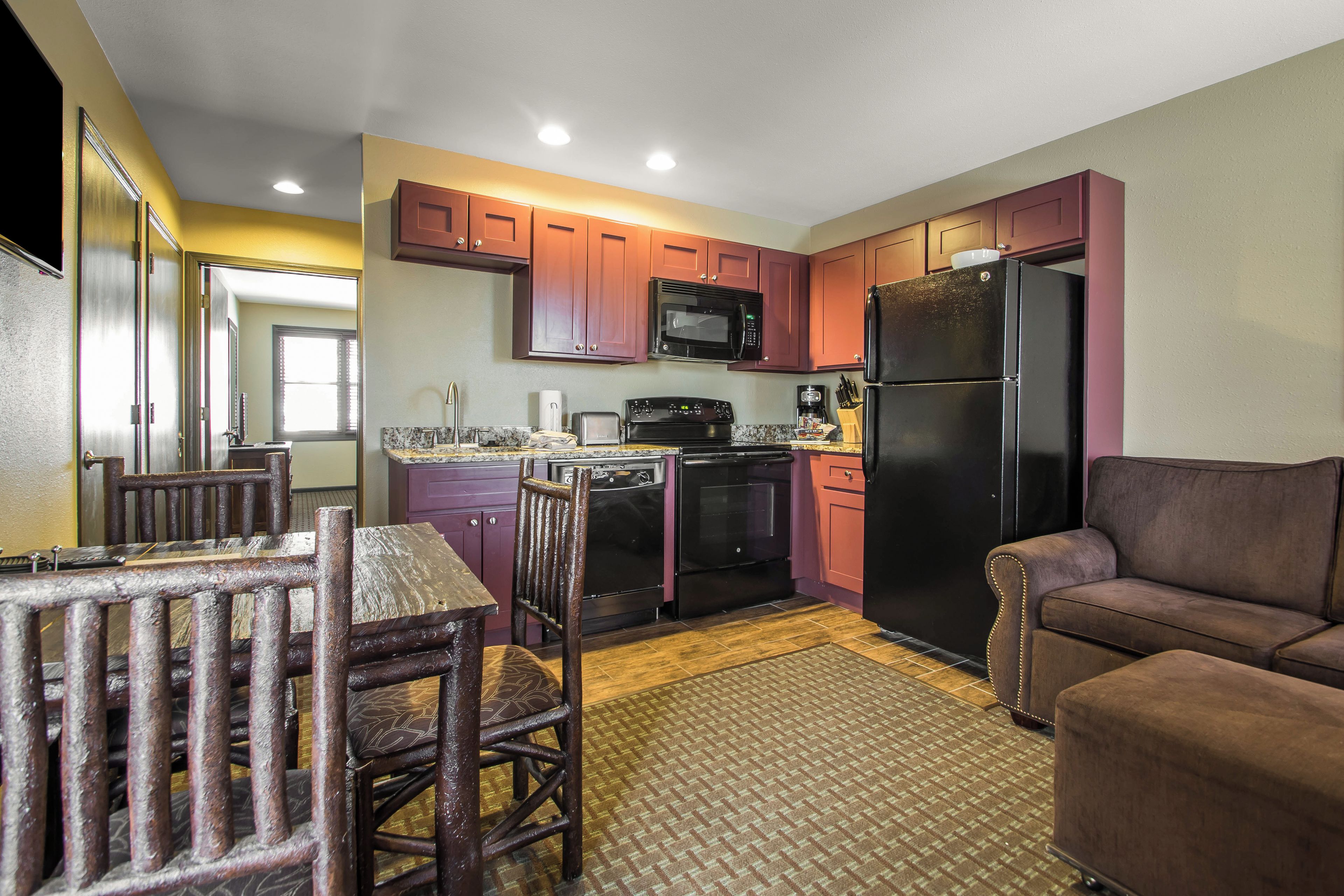 A compact kitchen with a dining area, a refrigerator, and a microwave.