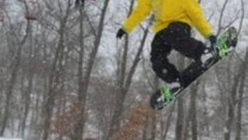 Eine Person snowboardet eine Piste hinunter.