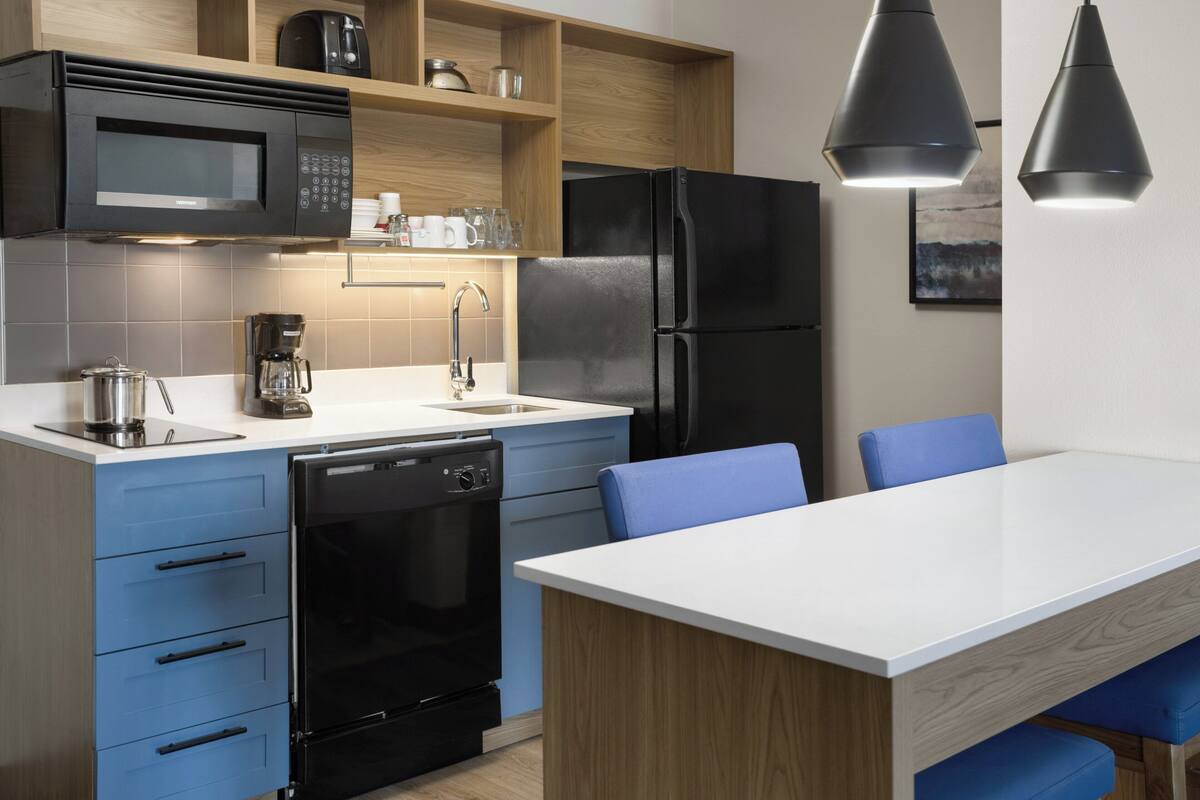 A modern kitchen with a microwave, coffee maker, dishwasher, and refrigerator.