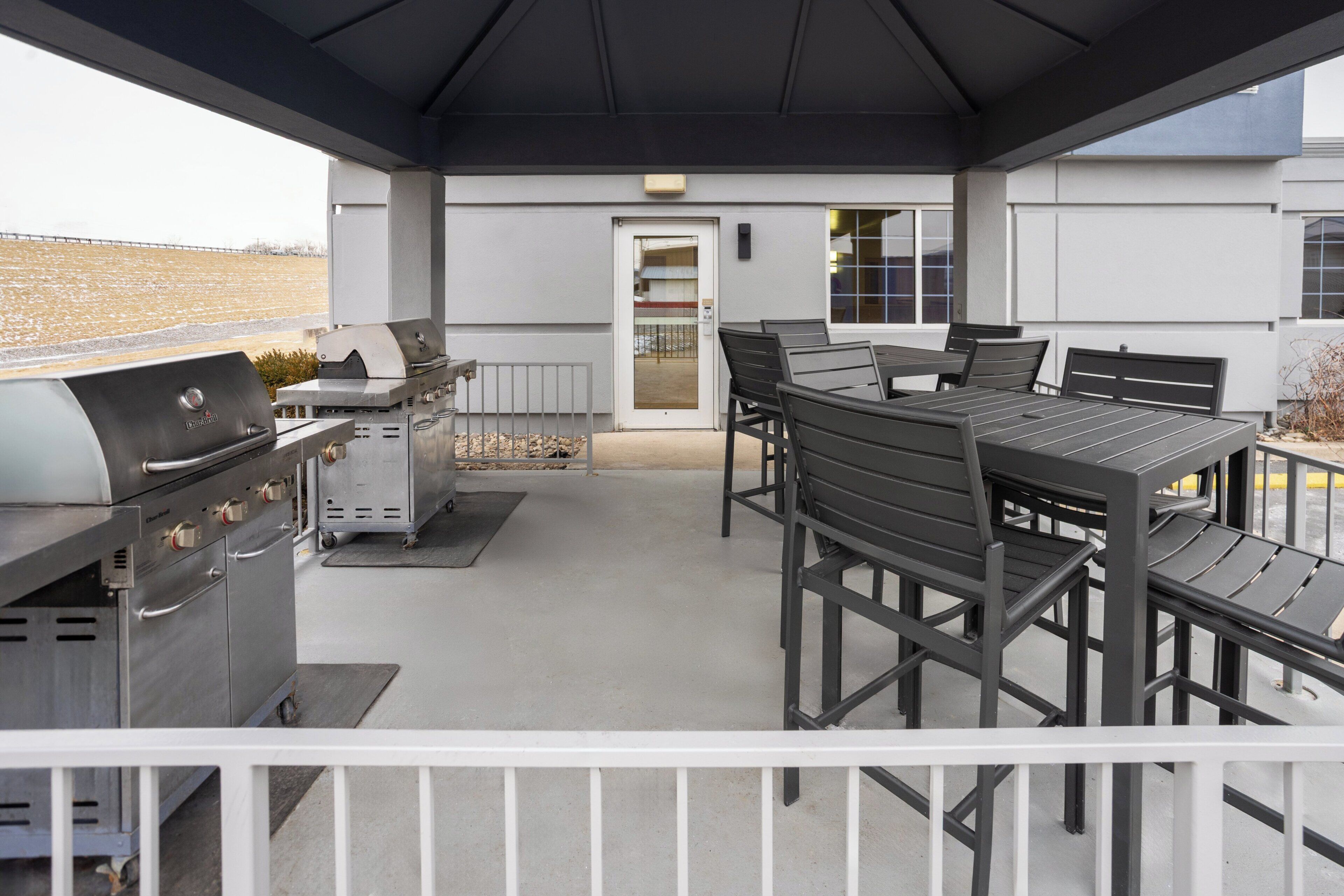Un patio exterior con una parrilla, zona de estar y vistas al paisaje.