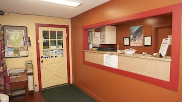 A reception area with a desk, a bulletin board, and a door.