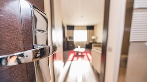 Un pasillo con una puerta de madera y vista a un cuarto con una mesa y sillas para comer.