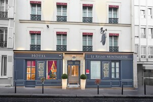 A hotel facade with a classic design, featuring a central entrance, large windows, and a sign indicating it is a hotel.