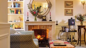 A cozy living room with a fireplace, a bookshelf, and a comfortable seating area. - Le Relais Montmartre (Paris)