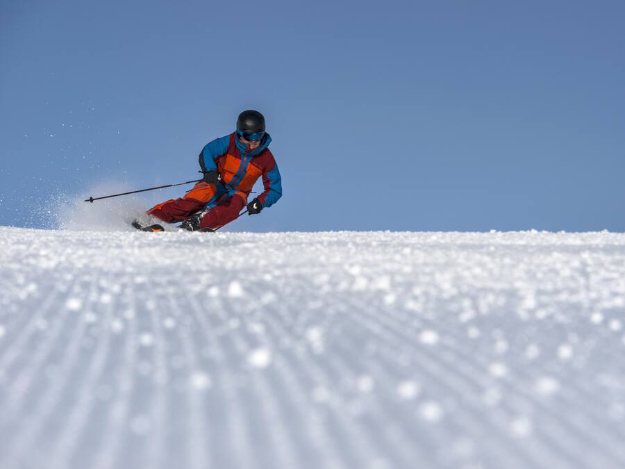 Iemand skiet een besneeuwde helling af.