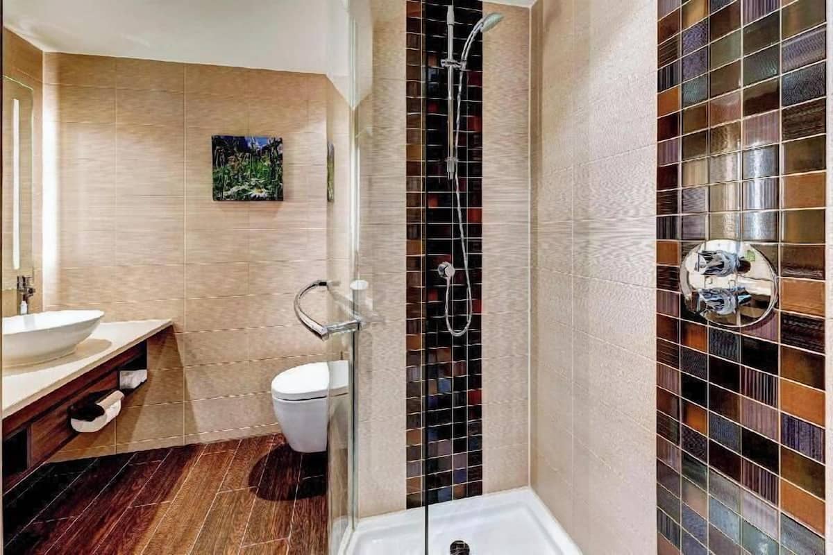 A bathroom with a shower, toilet, and sink.