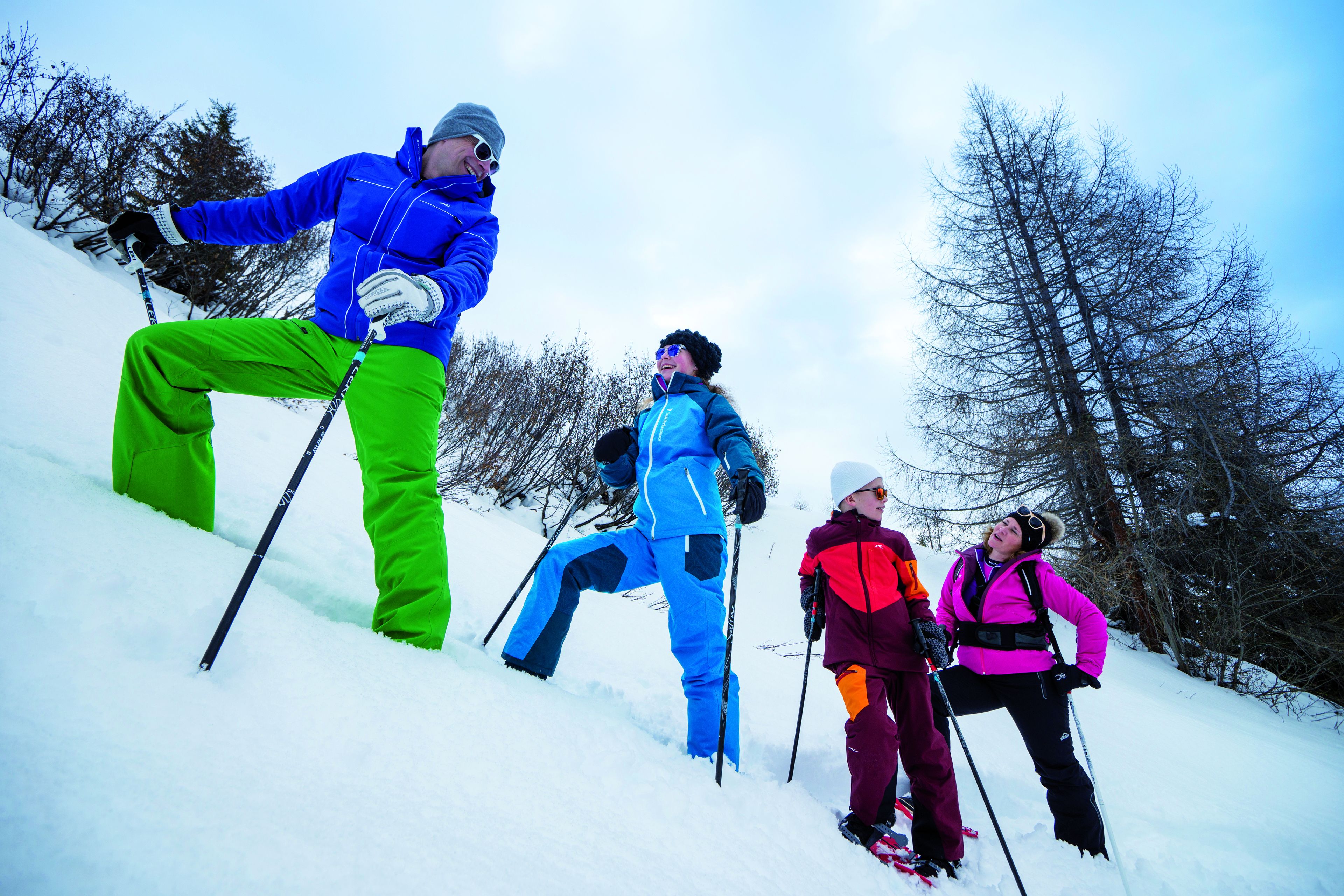 Eine Gruppe von Personen fährt auf einem verschneiten Hang Ski.
