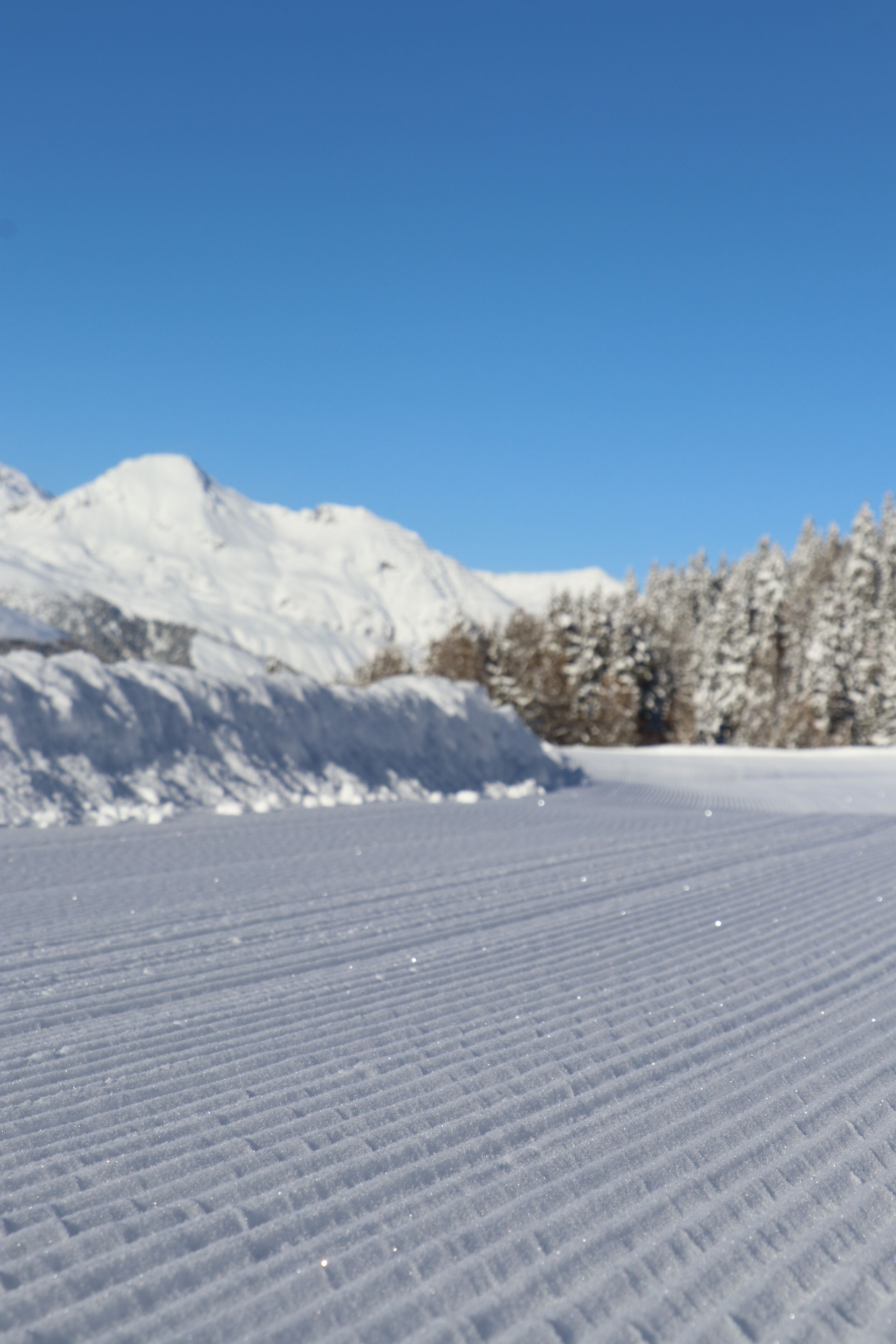 Eine verschneite Landschaft mit blauem Himmel.