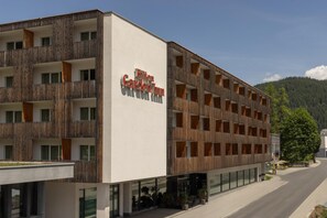 A multi-story building with a modern design, featuring a prominent sign for Hilton Garden Inn. - Hilton Garden Inn Davos (Davos)