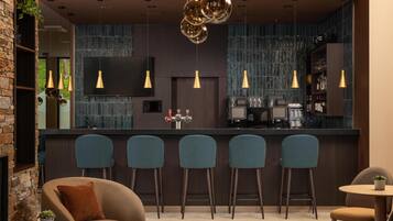 A modern bar area with a counter, bar stools, and pendant lighting.