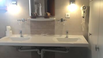 Un bagno moderno con due lavabi, uno specchio e un asciugacapelli.