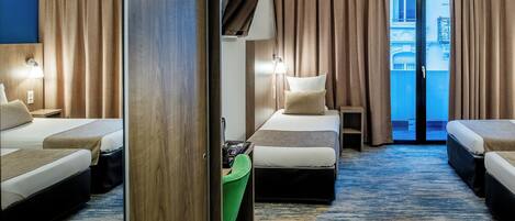 Habitación de hotel con dos camas, un escritorio, una silla, un televisor y vistas al exterior.