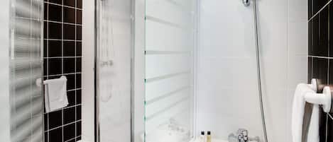 Un baño moderno con ducha envuelta en vidrio, bañera separada y mampara de cristal.