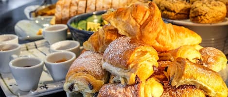 A variety of pastries and small cups on a tray, likely for a breakfast or snack service.
