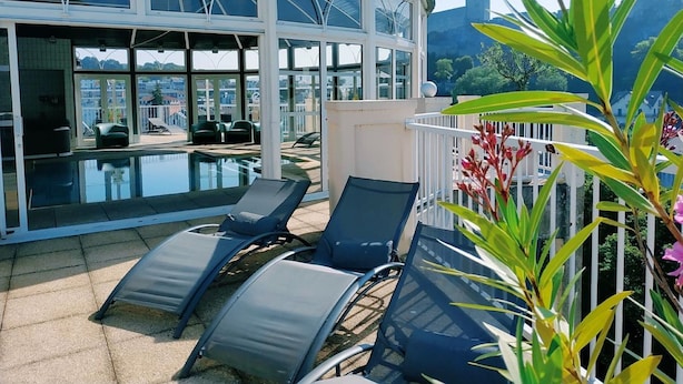 A rooftop pool area with lounge chairs and a glass-enclosed structure. - Hotel La Solitude (Lourdes)