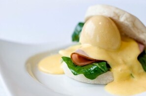 A dish with eggs, ham, and spinach on a white plate. - Sugar Hotel (Cape Town)