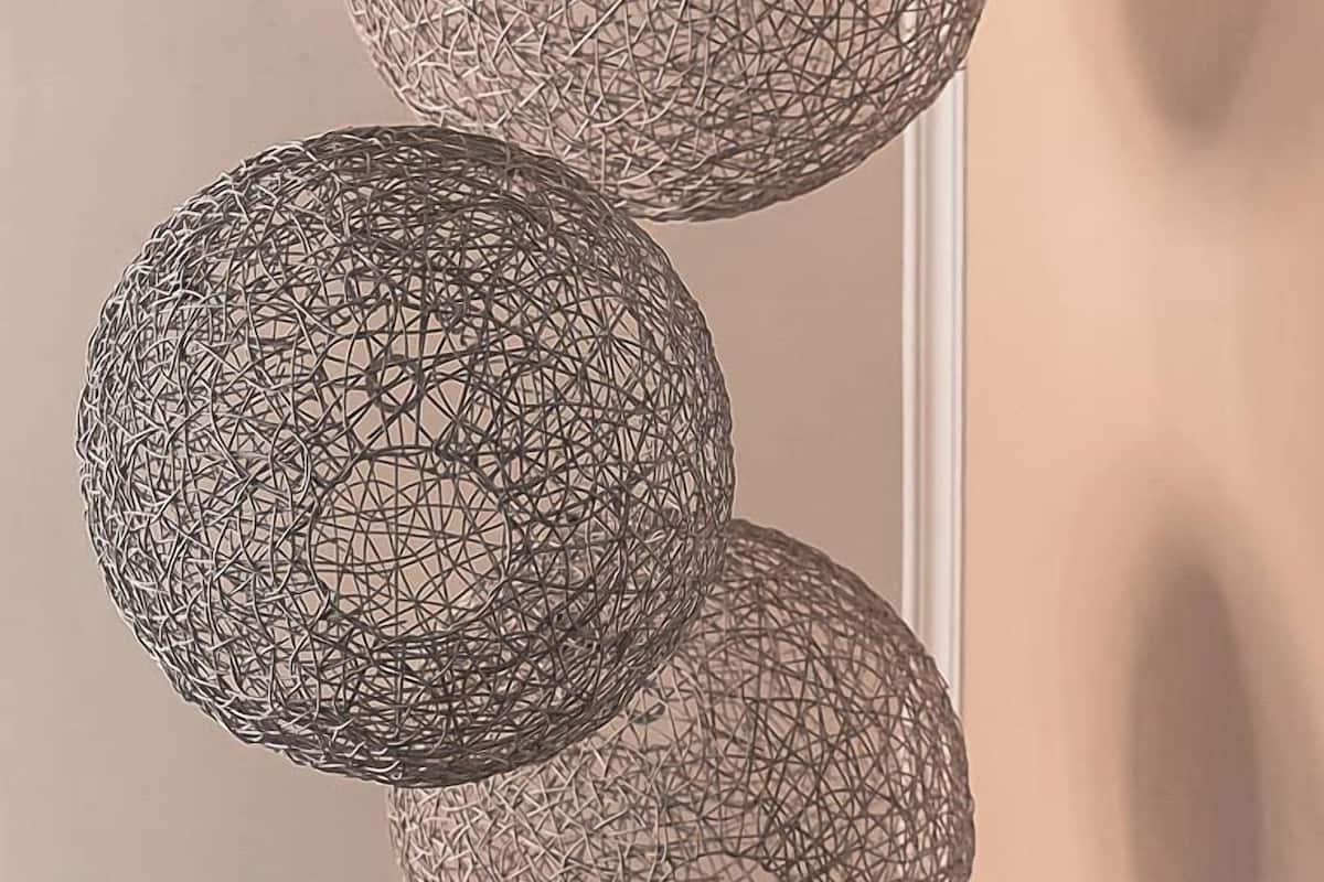 Three spherical, wireframe pendant lights hanging from a ceiling.