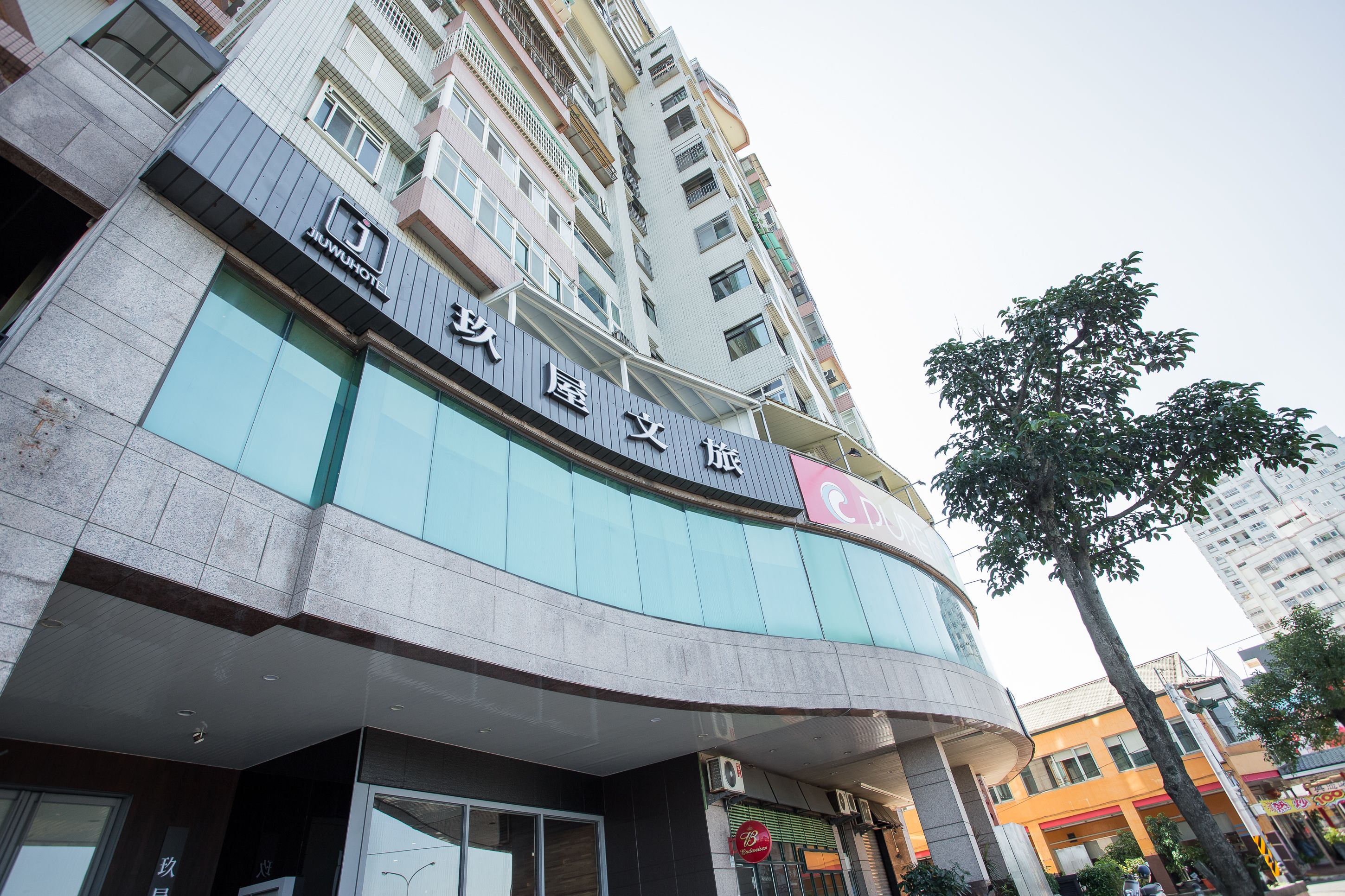 Un hotel de varios pisos con un letrero llamativo en un idioma extranjero.