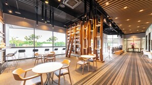 A modern library with bookshelves, tables, and chairs. - Jiuwu Hotel (Luodong)