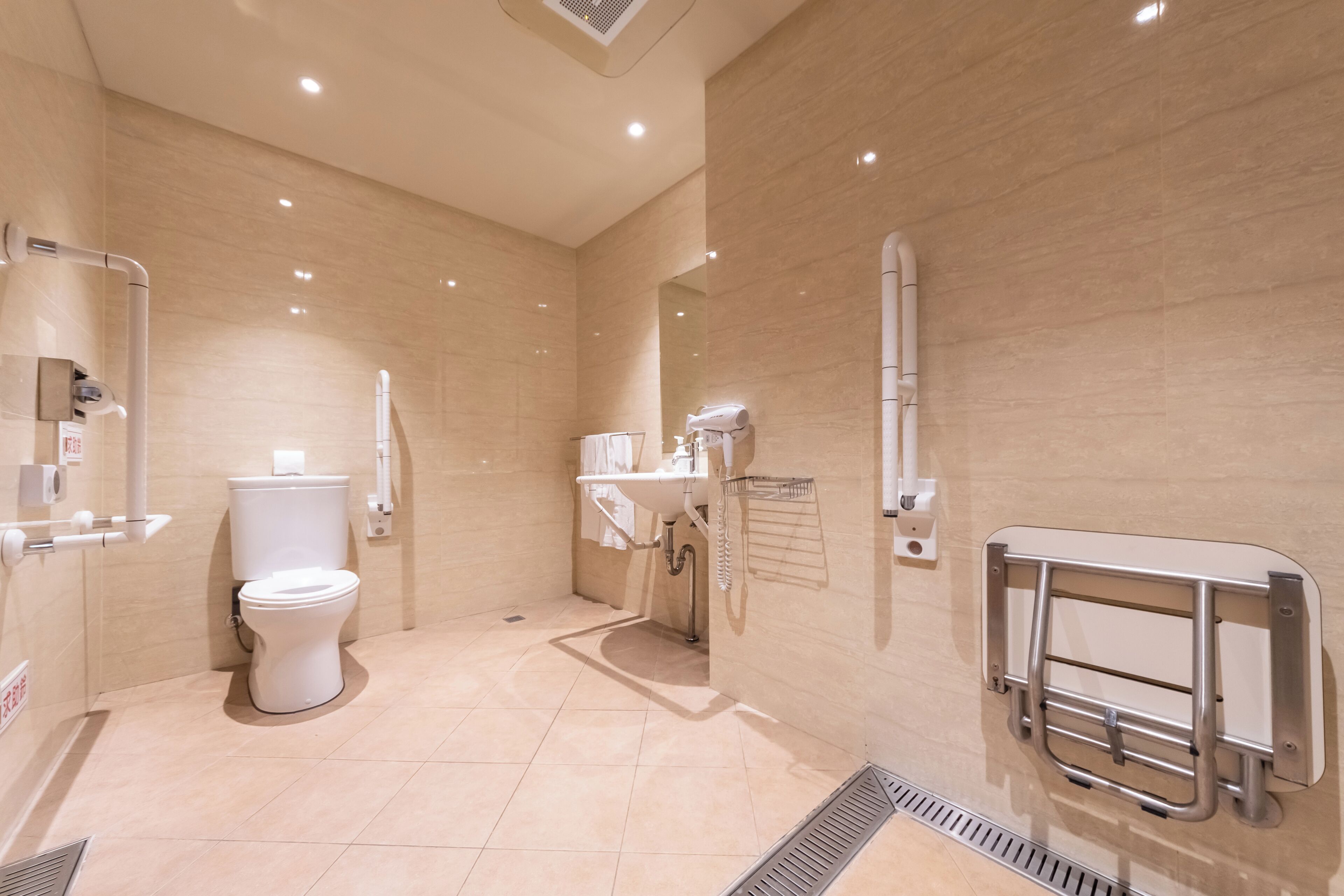A modern bathroom with a toilet, sink, and hand dryer.