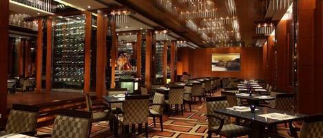 A hotel lobby with a shoe display, checkered chairs, and a patterned carpet.