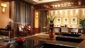 A hotel lobby with a seating area, a reception desk, and framed artwork on the walls. - Beijing Minzu Hotel    (Beijing)