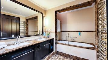 Une salle de bain moderne avec un meuble-lavabo à deux vasques, une baignoire sur pieds et un grand miroir.