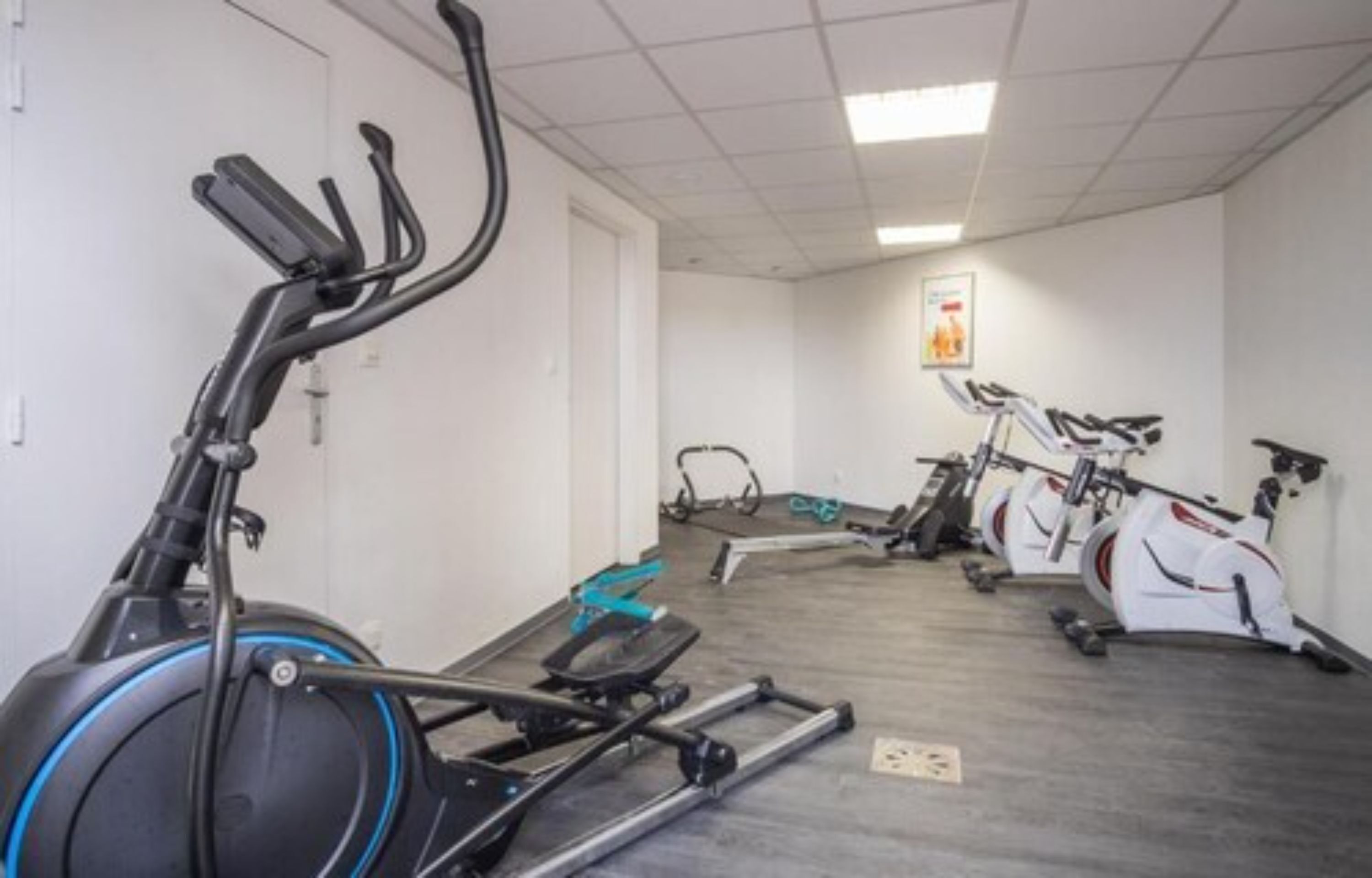 Une salle de sport équipée de vélos d'exercice et de tapis de course.