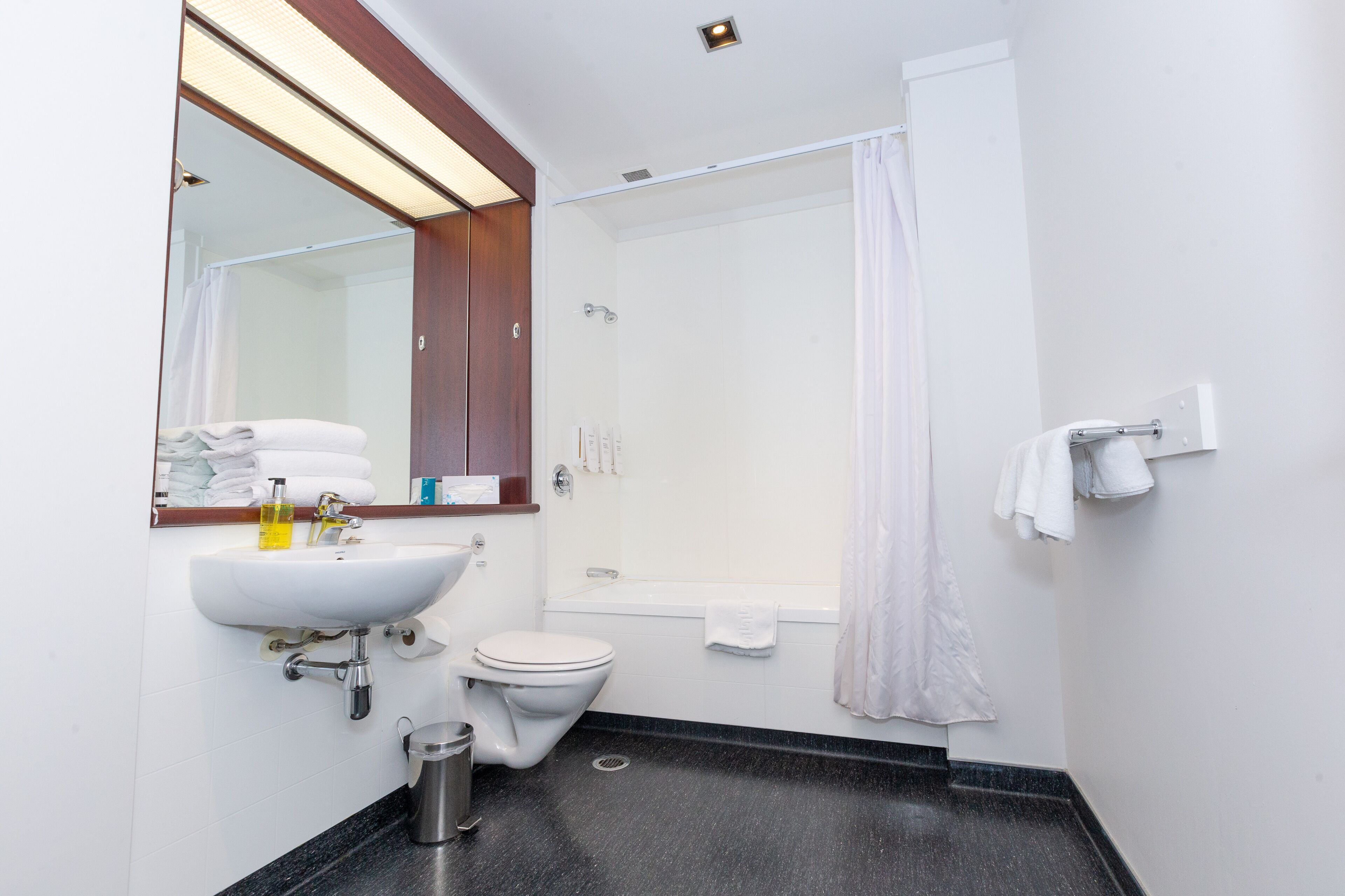 Un baño moderno con lavabo, inodoro y bañera.