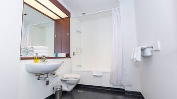 Un baño moderno con lavabo, inodoro y bañera.