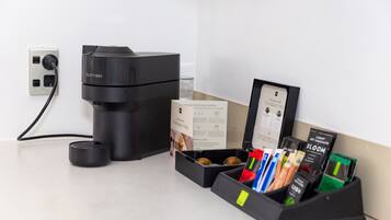 A Nespresso coffee machine, a coffee pod holder with various pods, and a welcome card.