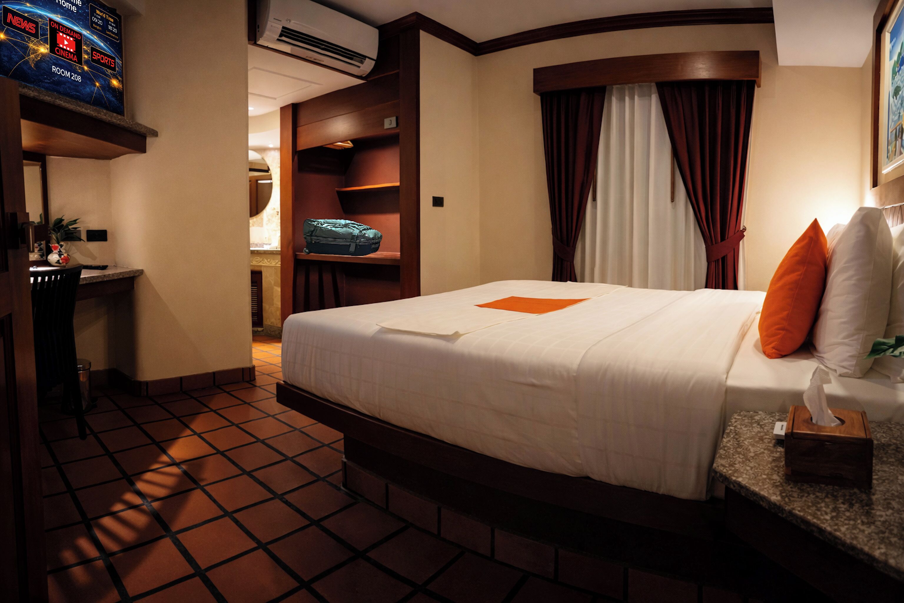 Una habitación de hotel con cama, escritorio, televisor y ventana con cortinas.