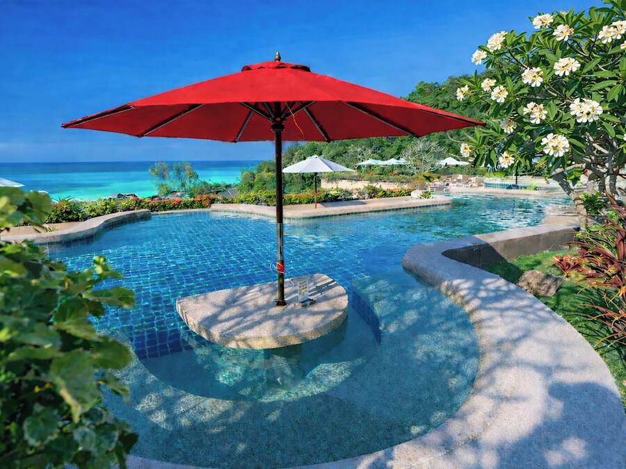 Una piscina al aire libre, sombrillas, tumbonas