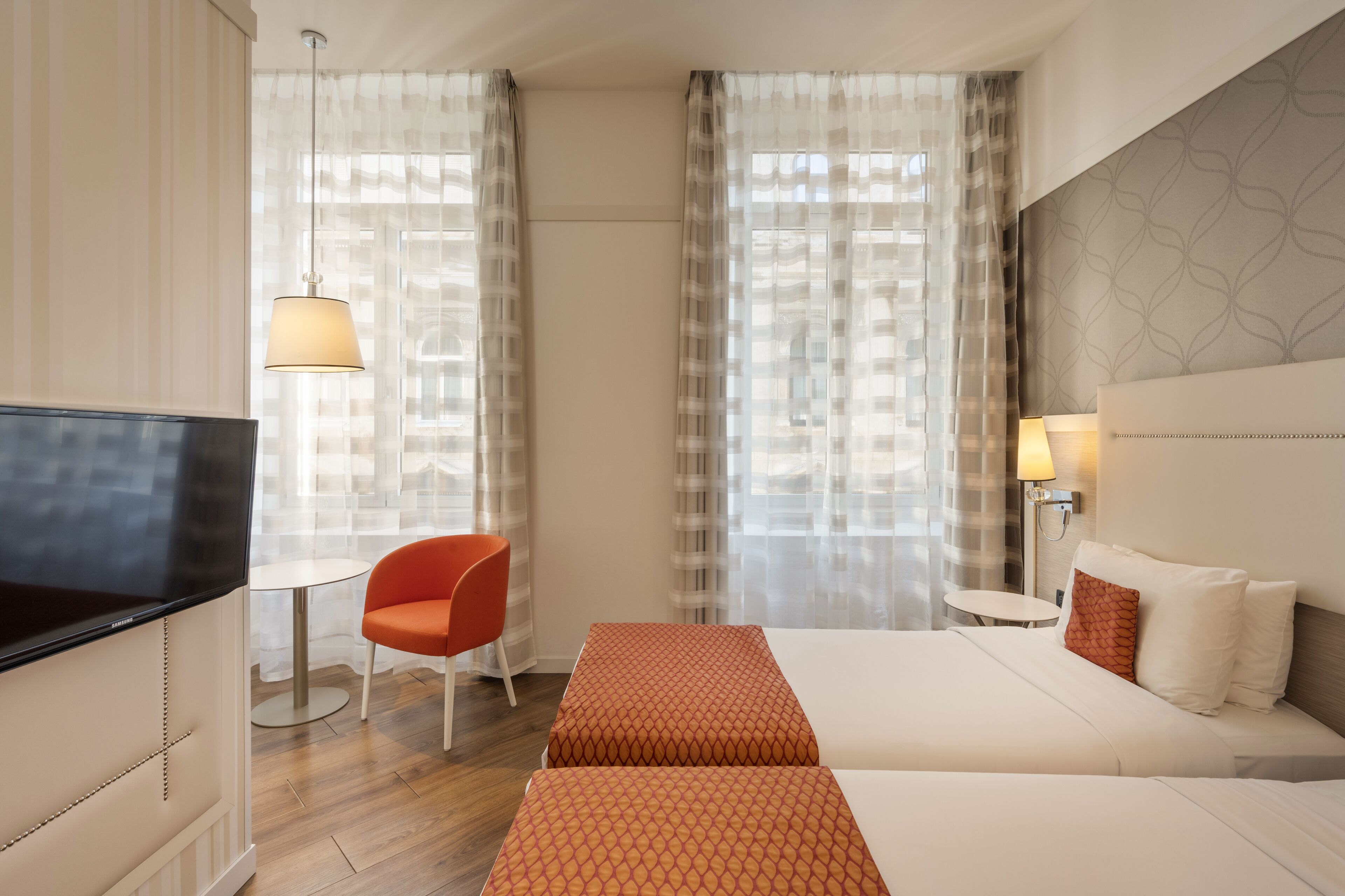 Une chambre d’hôtel avec un lit, une télévision, une chaise et une table.