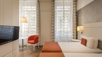 Une chambre d’hôtel avec un lit, une télévision, une chaise et une table.